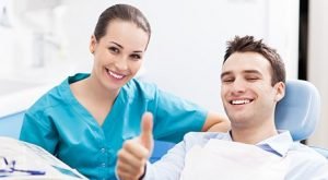 Man giving thumbs up while in the dentist chair